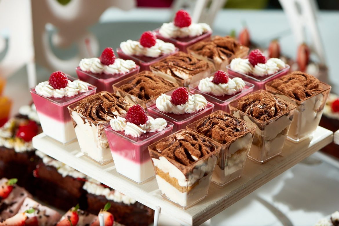close-up-of-a-tray-ful-of-delicious-jelly-desserts-raspberry-and-chocolate-flavors-whipped-cream-berries-chocolate-cacao-tiramisu-recipe-cooking-cusine-kitchen-party-candy-buffet